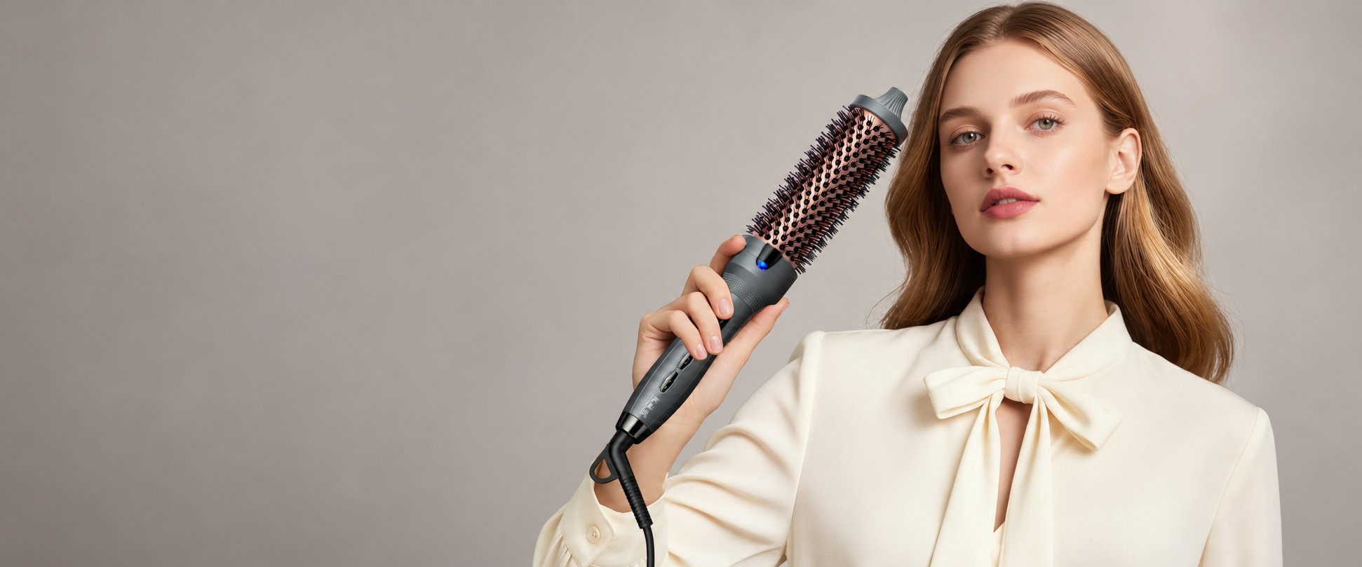 K&K model with chestnut hair and an ivory blouse holding the graphite thermal brush